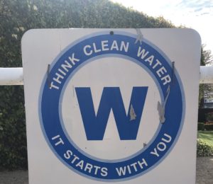 Beach sign saying "Think Clean Water - It Begins with You"
